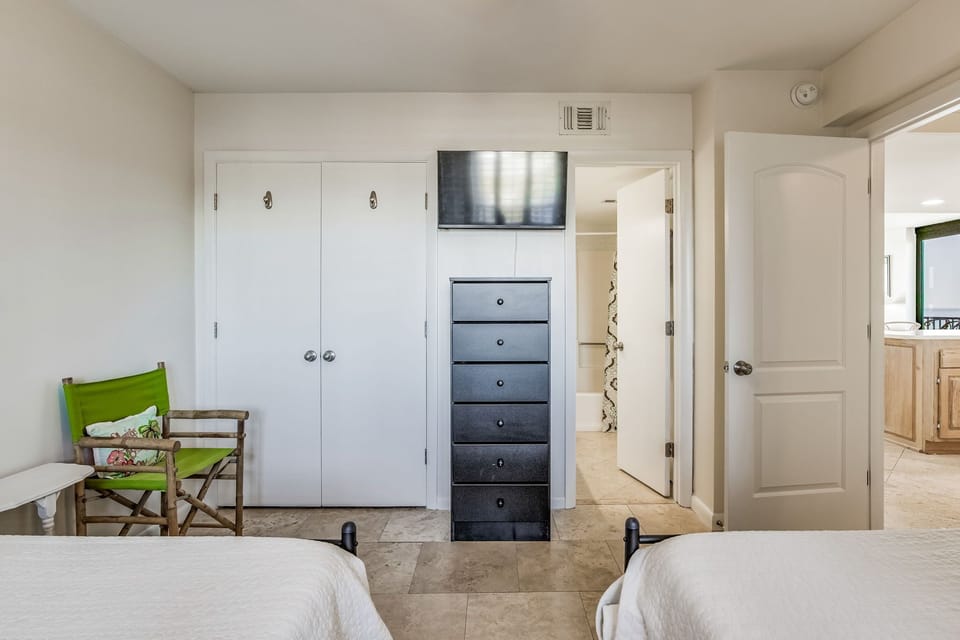 Guest bedroom with two double beds and coastal décor at Wind Drift