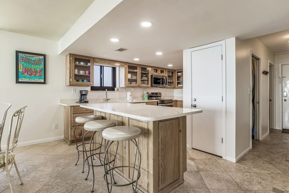 Kitchen with quartz countertops and pecky cypress cabinetry at Wind Drift 212 SW
