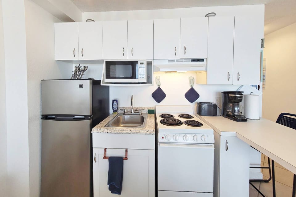 Whip up budget friendly meals in this kitchenette to cut eating out costs.