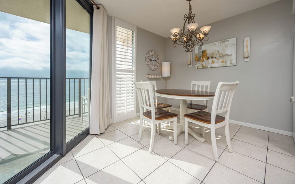 Dine at the round table under a chandelier while enjoying views through the large glass doors