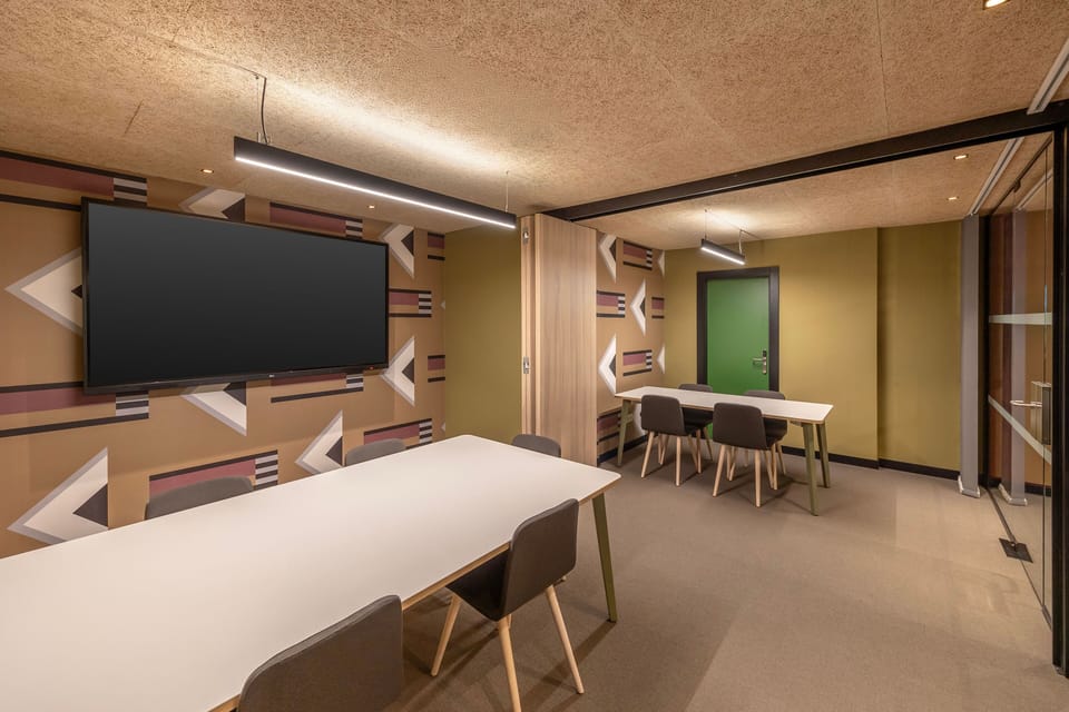 Modern meeting room with sleek tables and comfortable seating, ideal for productive gatherings or work sessions.