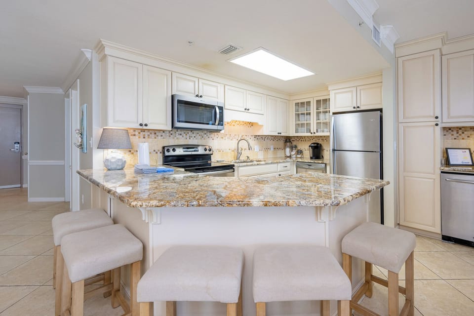 Granite breakfast bar surrounds the kitchen where you prepare fresh meals for family gatherings