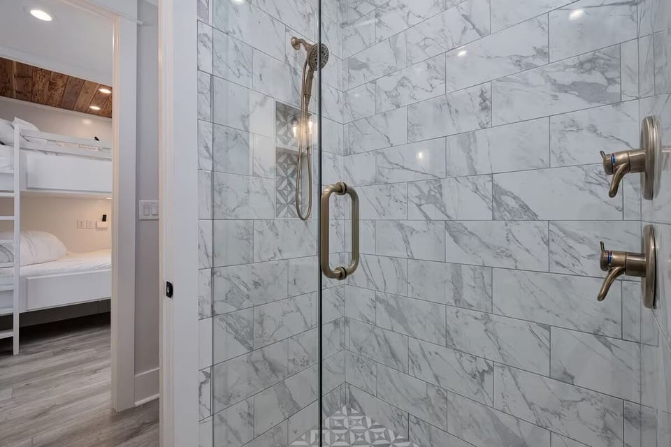 Jack-and-Jill Bathroom 1 combines marble-look tile with a spacious walk-in shower, bringing a touch of luxury to your morning routine.