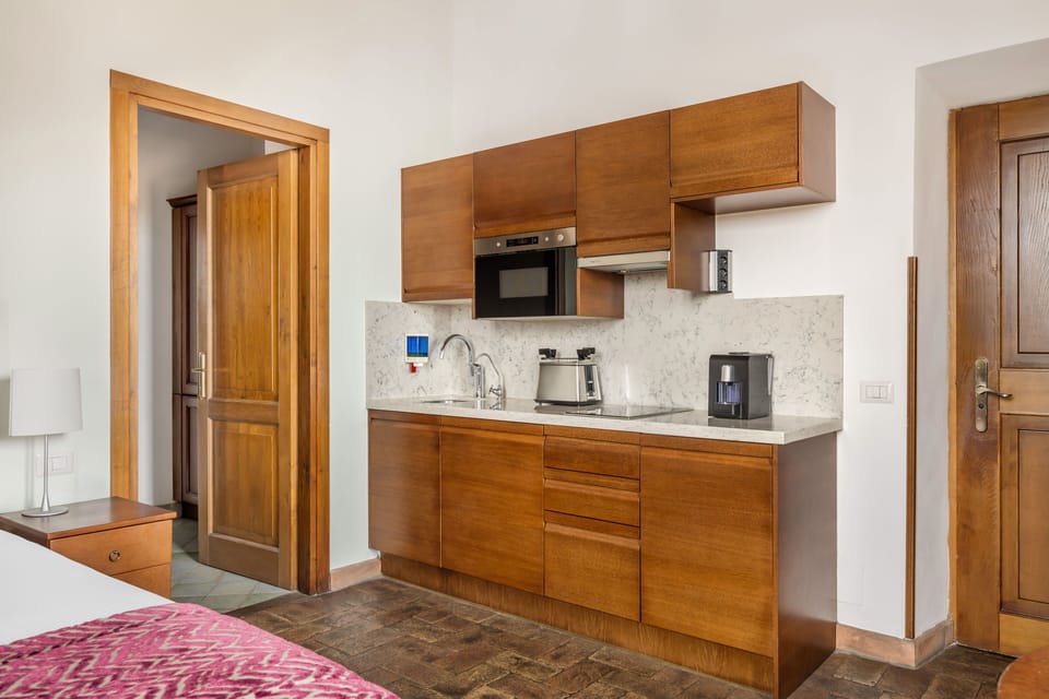 Prepare morning espresso in a warm, wood-accented kitchenette with modern touches.