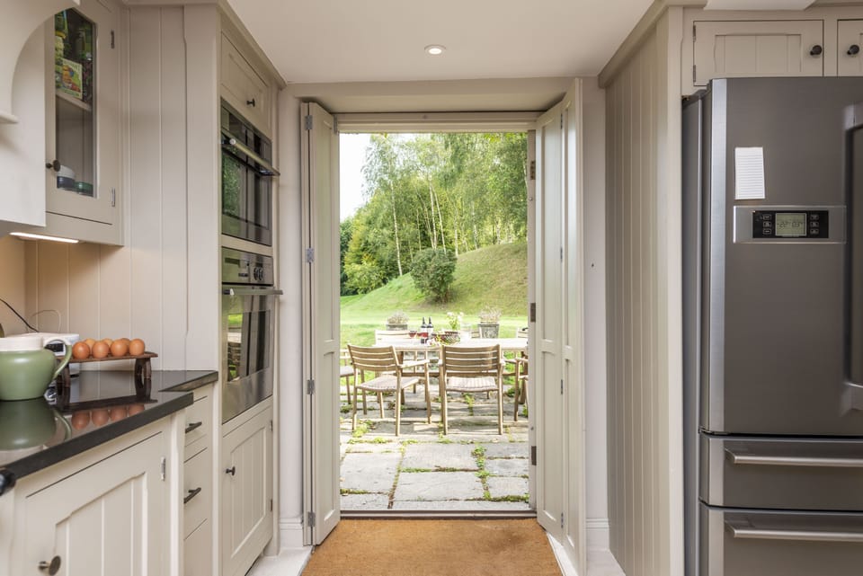 Manor Farmhouse, Cruxton: Kitchen with doors to the garden