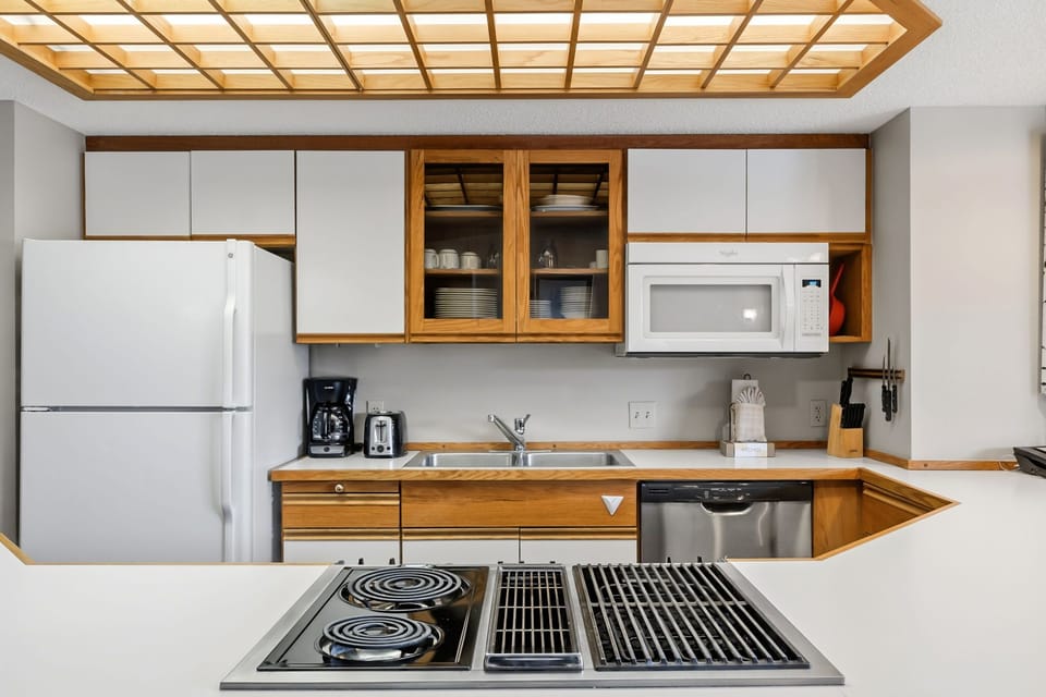 Your fully-equipped kitchen awaits with modern appliances, warm wood cabinetry, and everything you need to create memorable meals during your stay.