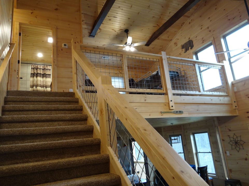 Stairway to upstairs queen bedrooms, bath and loft w/full bed & bunk beds