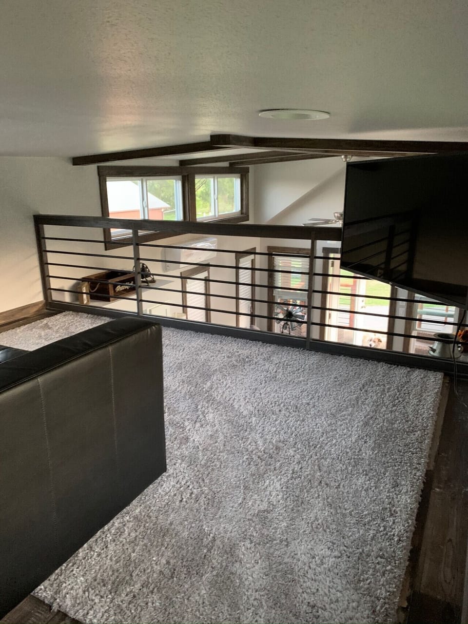 Second story loft with couch and tv