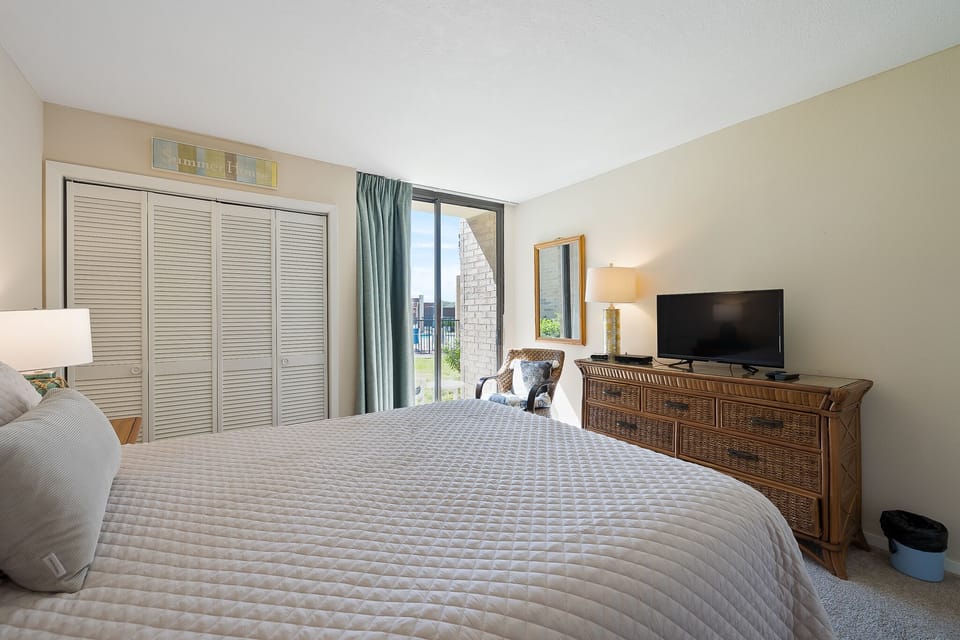 Guest bedroom with patio access leading to the pool area!