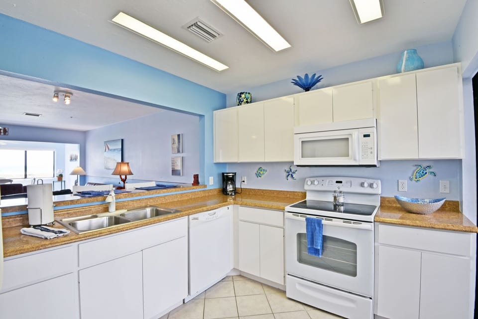 Kitchen with white cabinetry, full appliances, and tile countertops