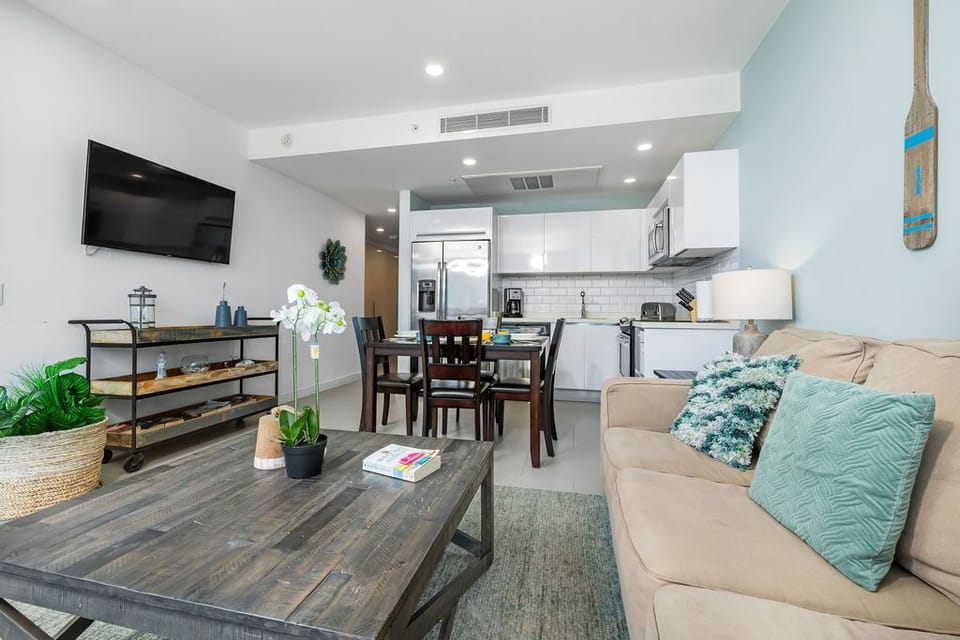Settle into your bright, modern retreat where soft coastal tones and an open-concept layout invite relaxation. Unwind on the cozy sofa, cook in your well-appointed kitchen, or enjoy meals at your dining table.