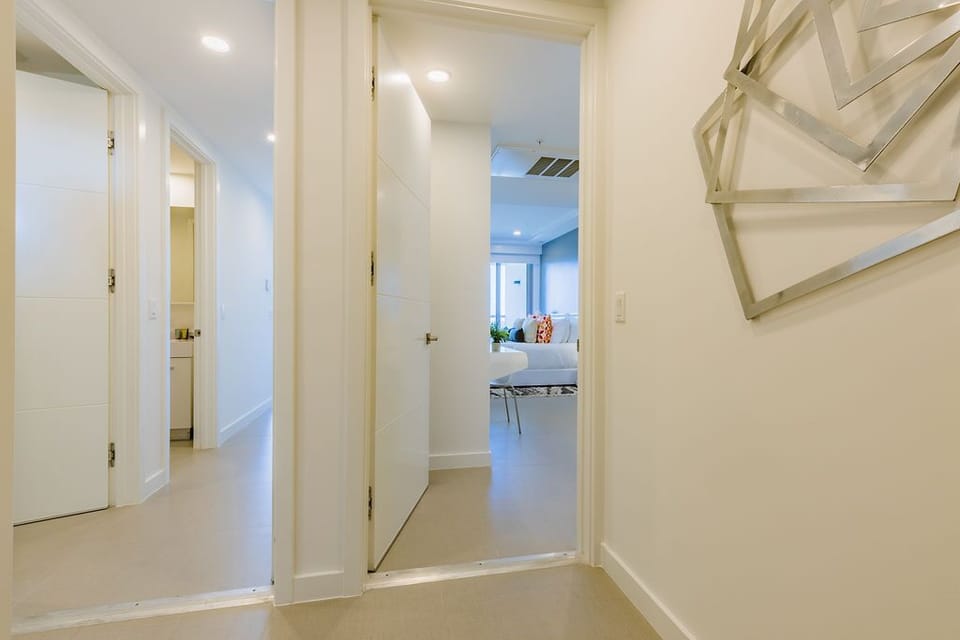 A bright, inviting hallway connects your private spaces with the main living areas, featuring clean lines, soft lighting, and convenient storage to keep your stay organized.