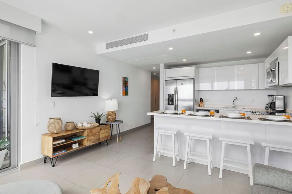 Gather around the breakfast bar in your bright, modern kitchen, ready for easy meals and coastal-inspired living. Clean lines, natural light, and thoughtful details create a welcoming space for relaxation.