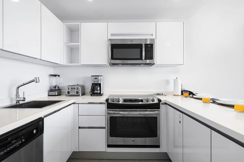 Your fully-equipped kitchen with stainless steel appliances, white cabinetry, and all the essentials you need to prepare meals—from morning coffee to home-cooked dinners.