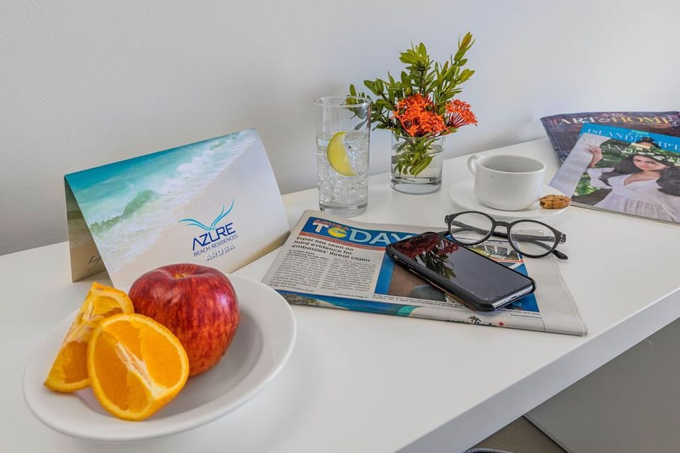 Enjoy fresh fruit and morning coffee at your bedside table, where every thoughtful detail—from fresh flowers to local reading—invites you to ease into island time.