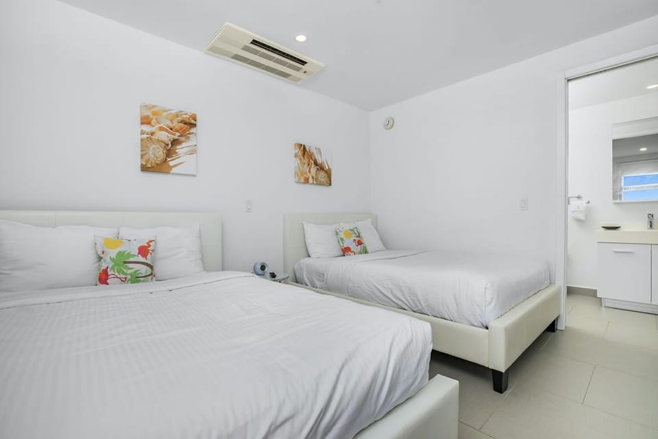 Sink into crisp white linens across two spacious beds, perfect for your group. Modern air conditioning keeps you comfortable while cheerful artwork adds warmth to this bright, peaceful retreat.