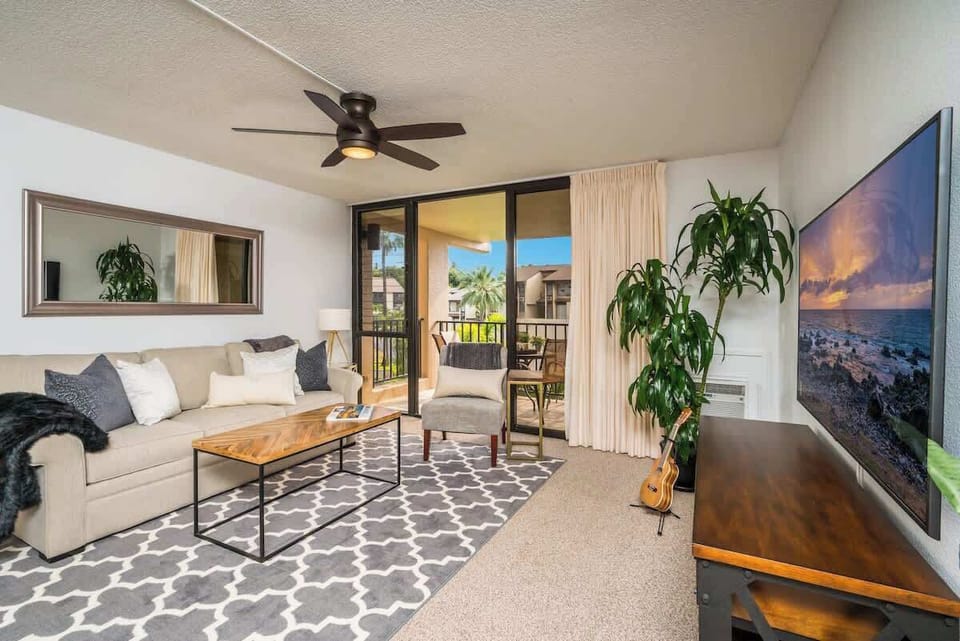 Enjoy the cozy living room with a large TV and direct access to the balcony for fresh air and views.