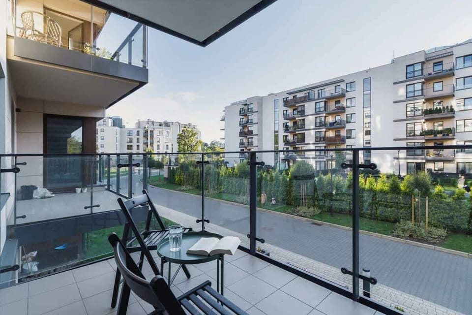 Spacious balcony with outdoor furniture. 