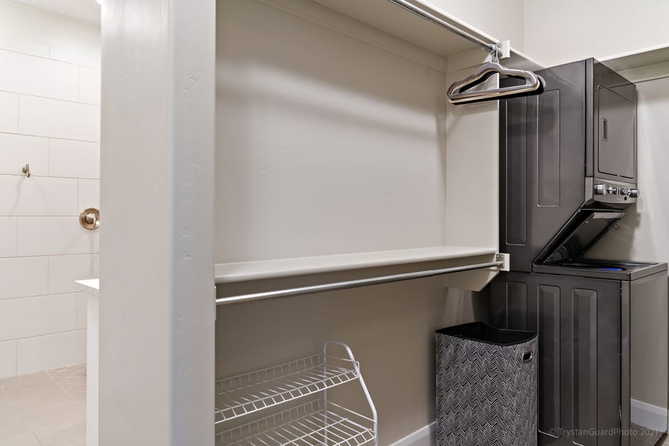 Laundry room featuring a closet with hangers and laundry soap