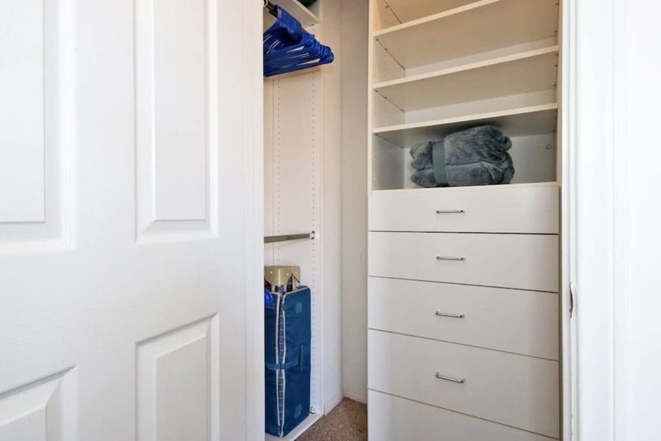 Primary Suite 1: Walk in closet with pack and play, extra blankets, iron, ironing board, and plenty of hangers. 