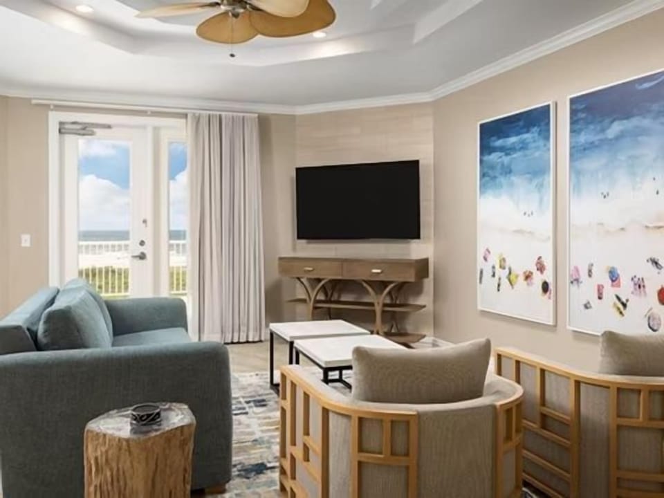 Teal sofa and accent artwork in the open living area — free Wi-Fi and cable TV included