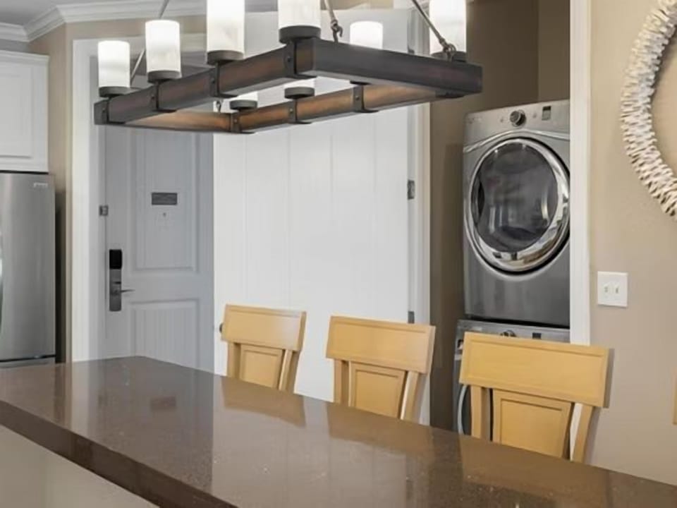 In-suite washer and dryer alongside bar stool seating at the kitchen counter