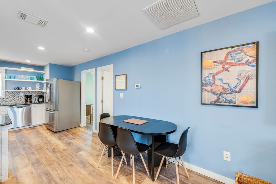 Gather around your sleek dining table in this cheerful blue space, where coastal artwork and modern style create the perfect spot for memorable meals.