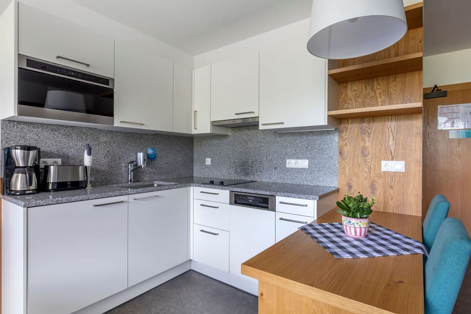 Fully equipped kitchenette featuring a hob, microwave, dishwasher, and coffee machine – everything you need to dine in.
