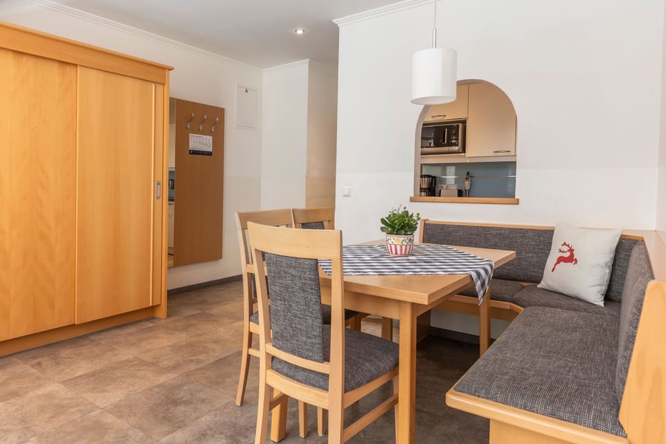 The spacious dining area includes a charming wooden table surrounded by comfortable seating, seamlessly connecting to the fully equipped kitchen for convenient meal preparation.