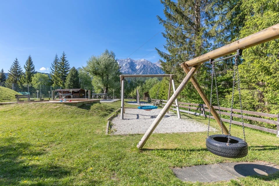 Peaceful play area surrounded by forest, ideal for children to enjoy the fresh mountain air.