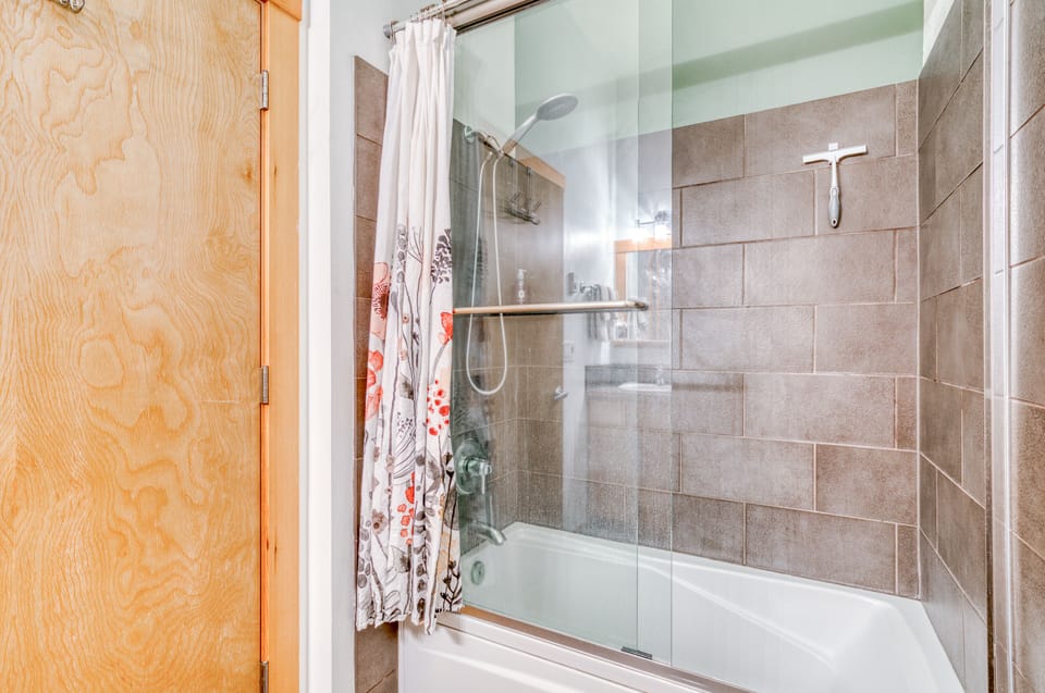 Tile shower with large hand held showerhead.