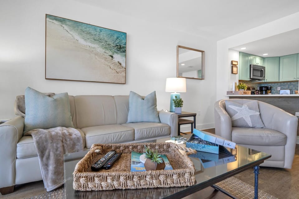 Sink into plush sofas in your bright living space, where coastal artwork and soft throws create the perfect spot to unwind after your adventures.
