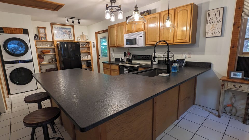 Well-equipped kitchen with full size refrigerator, stove, and new washer/dryer