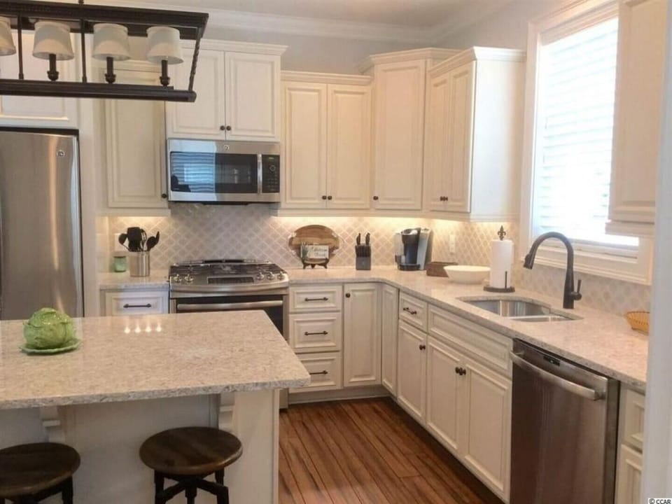 GOURMET KITCHEN W/ SS APPLIANCES, ISLAND W/ 3 BAR STOOLS & QUARTZ COUNTER TOPS!