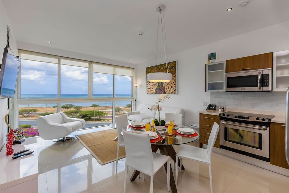 This bright, open-plan space combines your living, dining, and kitchen areas with sweeping ocean and coastal views. Picture yourself preparing meals in the modern kitchen, sharing relaxed dinners at the glass table, and unwinding on the comfortable seating