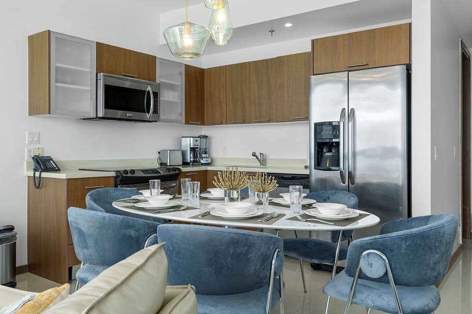 Gather around this beautifully set table and savor meals together in your modern kitchen, fully equipped with stainless steel appliances and elegant wood cabinetry.