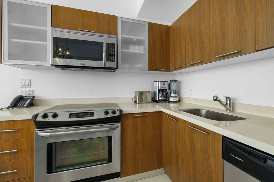 Your modern kitchen features warm wood cabinetry, sleek appliances, and everything needed to prepare meals at home with ease and style.