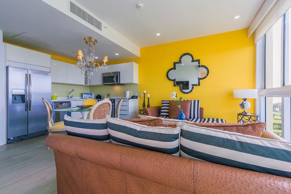 Bright, open living space where you'll love relaxing on plush striped seating, cooking in your modern kitchen, and enjoying coastal vibes with natural light flooding through large windows.