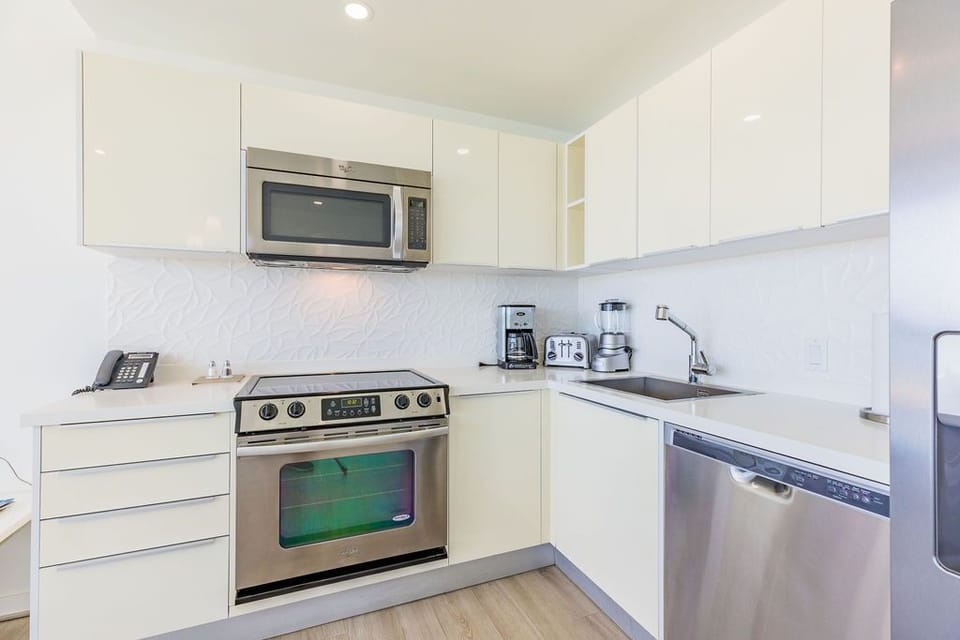 Your modern kitchen comes fully equipped with stainless steel appliances, sleek white cabinetry, and everything you need to prepare meals during your stay.