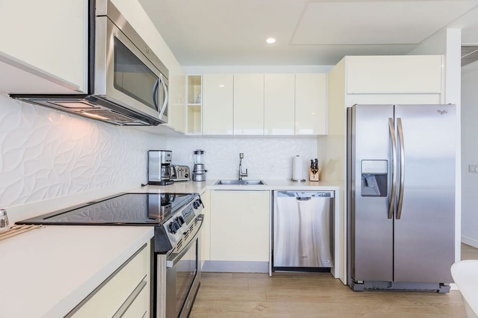 Your modern kitchen offers everything you need: gleaming stainless appliances, sleek white cabinetry, elegant countertops, and contemporary fixtures—all bathed in natural light for easy meal prep.