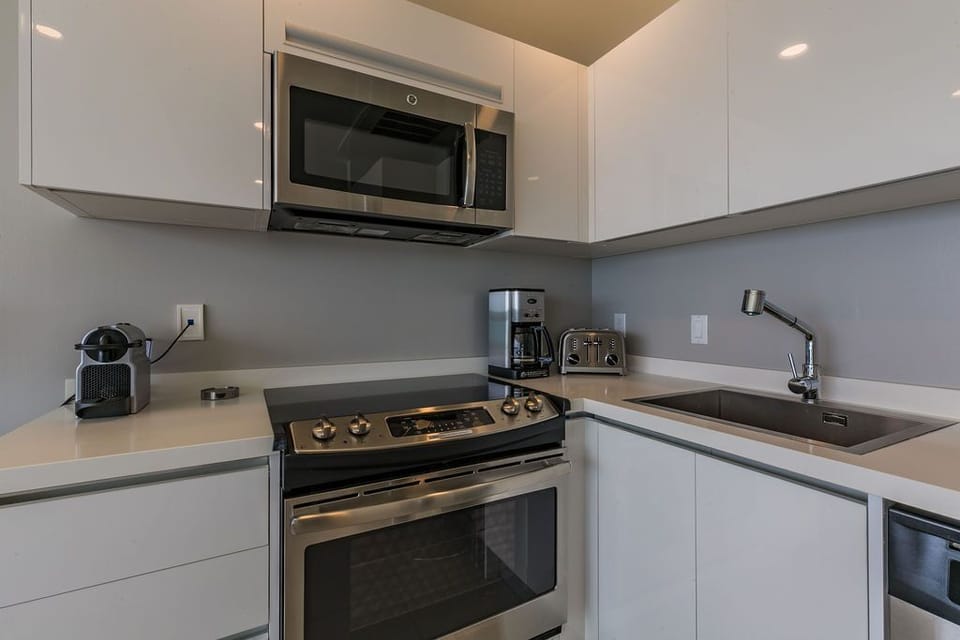 Your modern kitchen is equipped with everything you need—stove, oven, microwave, coffee maker, and toaster—plus sleek countertops perfect for meal prep.