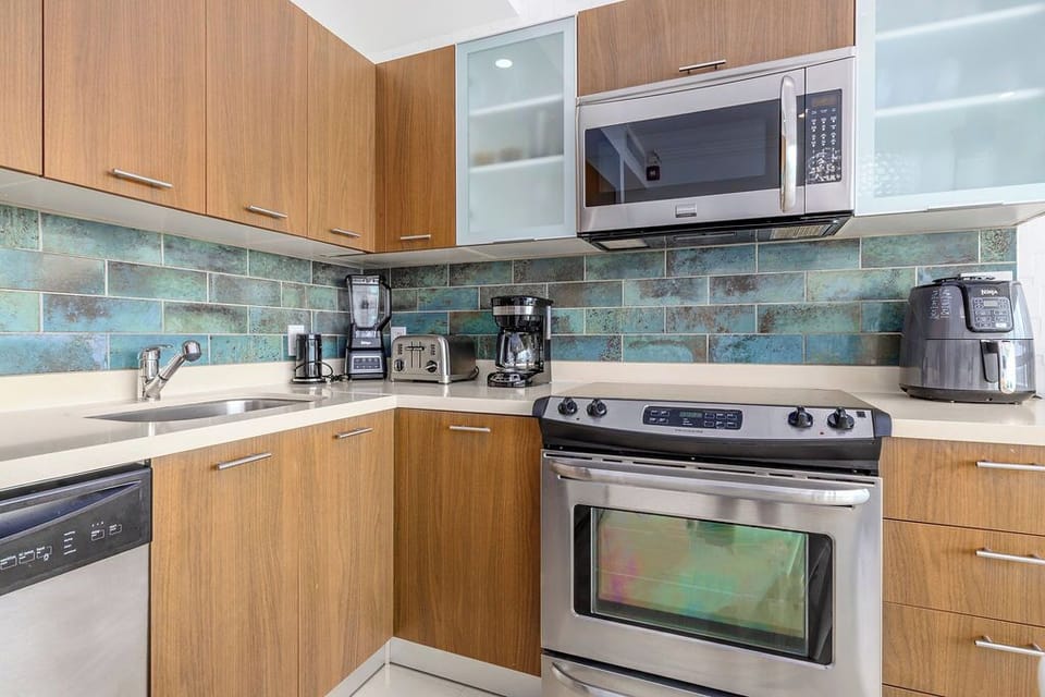 Your well-equipped kitchen features modern stainless appliances and warm wood cabinetry, plus coffee makers and a blender to fuel your mornings—perfect for easy vacation meals.