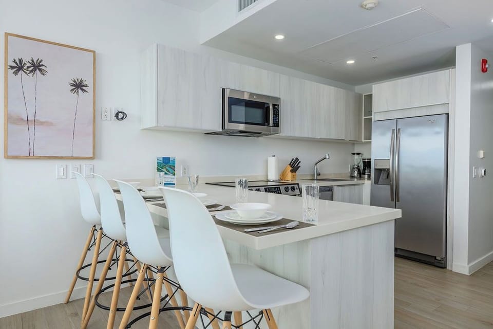 Your sleek, modern kitchen welcomes you with bright countertops, stainless-steel appliances, and a breakfast bar perfect for morning coffee or casual meals. Coastal touches add to the airy vibe.