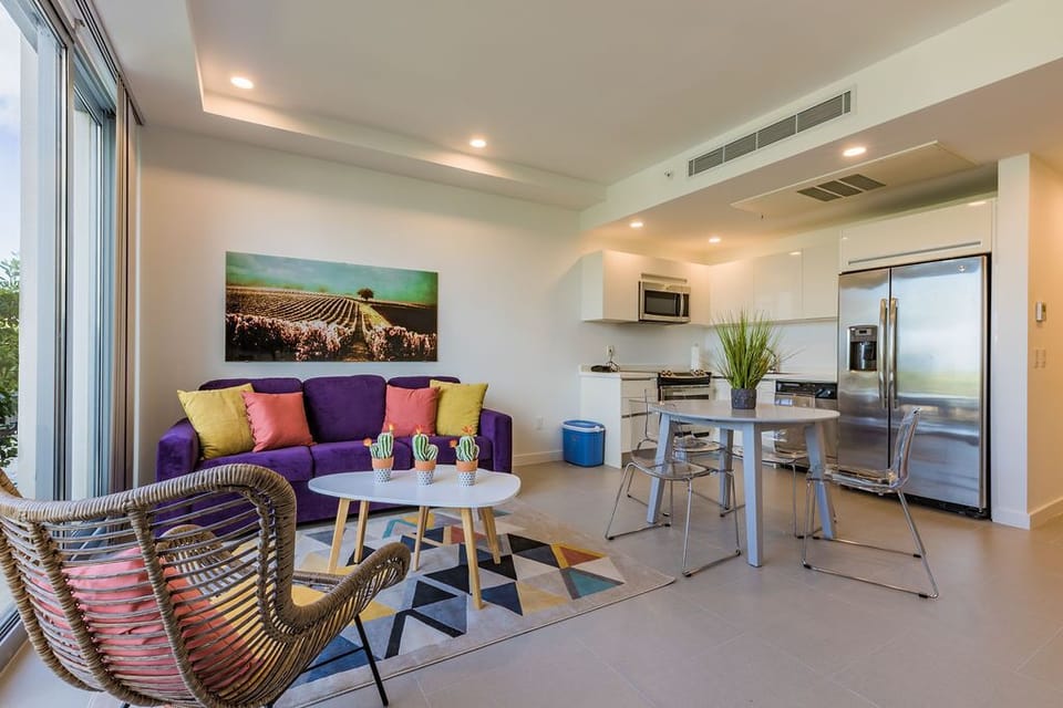Your open-concept living space awaits with modern comfort, where a vibrant living area flows seamlessly into a fully equipped kitchen—perfect for relaxing or whipping up meals during your stay.