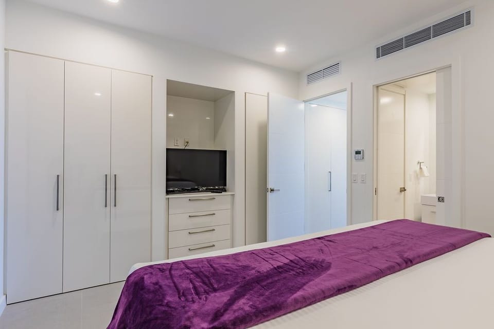 Your serene bedroom features sleek modern design with climate control, abundant storage, and an ensuite bathroom—everything you need for a restful stay.