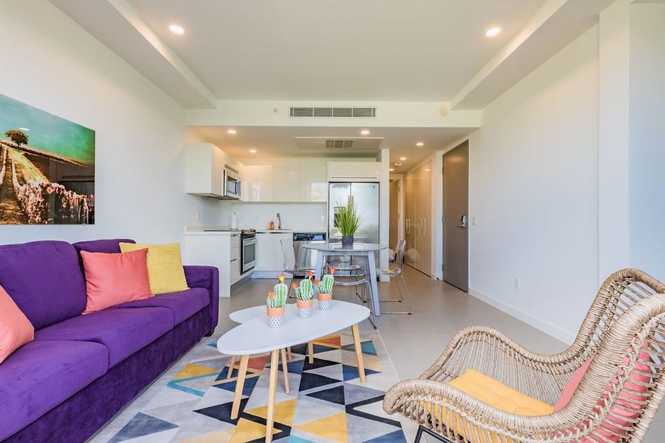 Your bright, open-concept space invites relaxation with a vibrant living area flowing into a fully equipped kitchen. Enjoy modern comfort with stylish touches, climate control, and colorful accents that bring the space to life.
