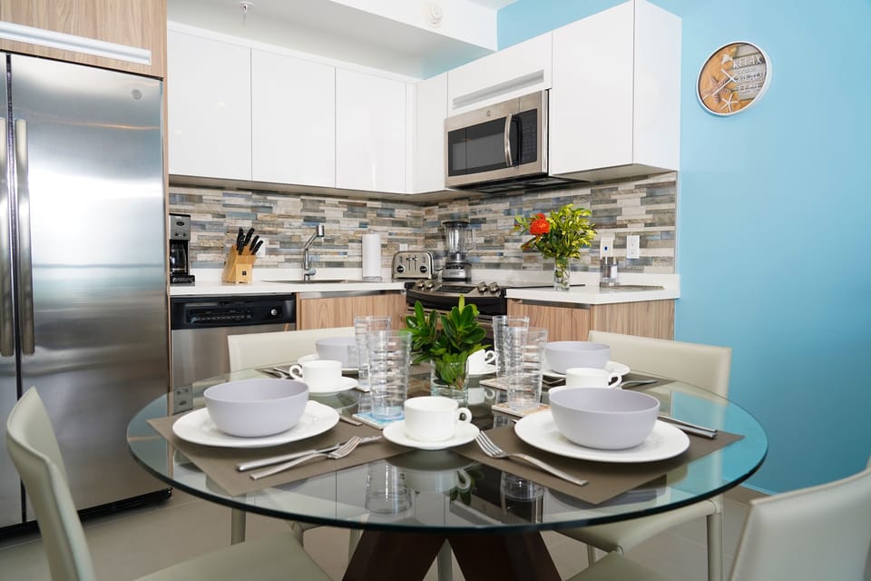 Your modern kitchen awaits with sleek appliances, stylish tile backsplash, and a welcoming dining table set for memorable meals together.