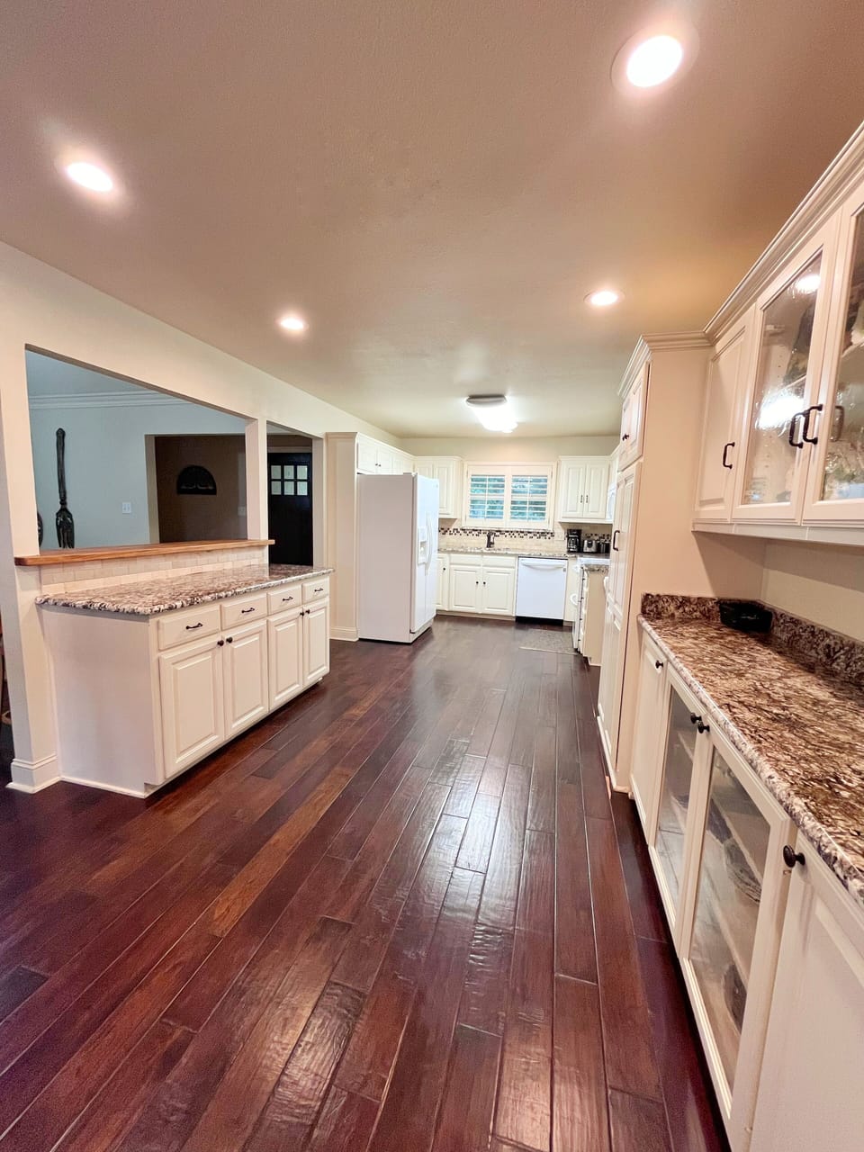 Kitchen includes bartop with 2  barstools adjacent to dining room
