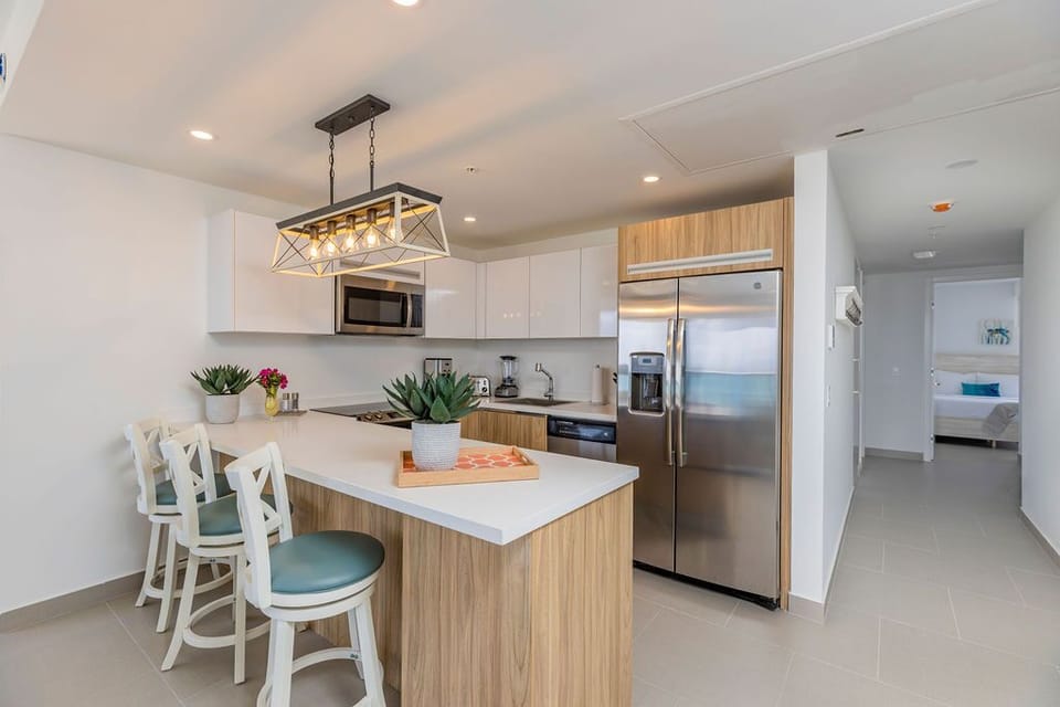 Picture yourself preparing meals in this bright, modern kitchen with its inviting island and sleek appliances, where cooking becomes a pleasure in your coastal retreat.