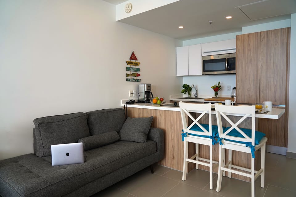 Settle into your bright, modern living space with a comfy sofa, fully equipped kitchen, and cheerful breakfast bar—perfect for sipping morning coffee or unwinding after exploring nearby beaches.